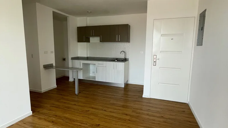 Sala y cocina entregadas de un apartamento en Acacias Garden II, con piso tipo madera y desayunador