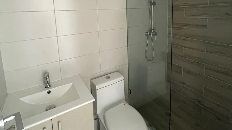 Baño terminado con ducha de vidrio en un apartamento de Acacias Garden II
