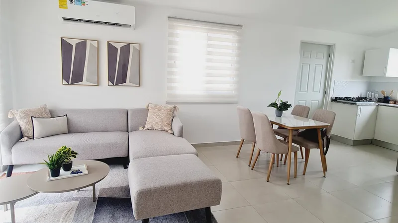 Sala-comedor y cocina abierta de la casa modelo de Alamedas del Valle, con aire acondicionado y piso de porcelanato