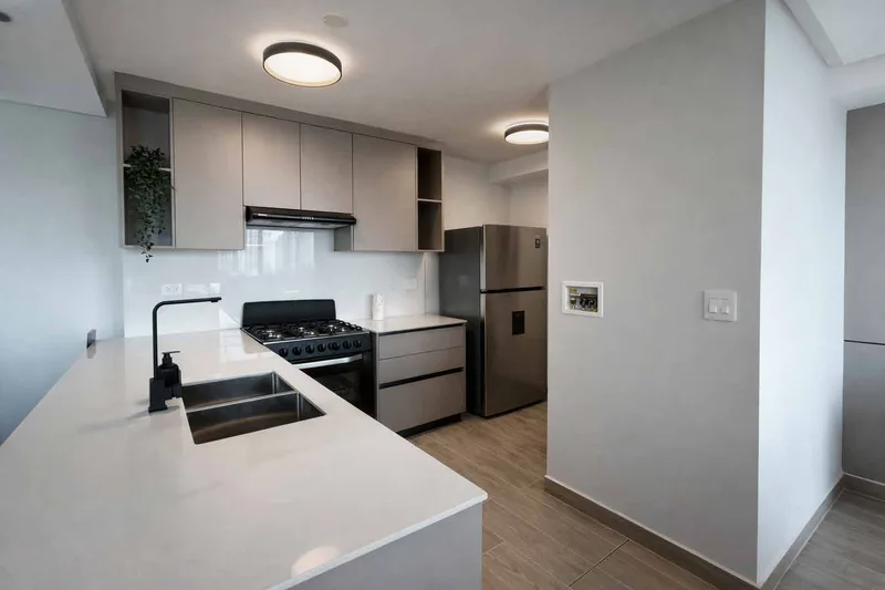 Cocina con sobres de granito y muebles empotrados en PH Omar Park View